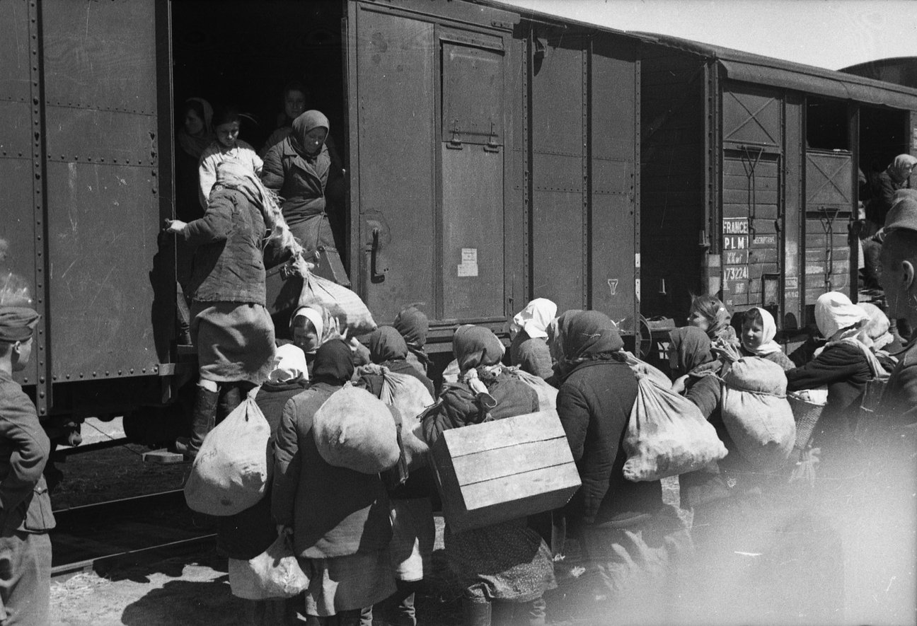 Ukrainerinnen, die zur Zwangsarbeit nach Deutschland verschleppt werden, steigen in Güterwaggons, Frühling 1943, BArch 101I-086-3559-10 Ukrainerinnen, die zur Zwangsarbeit nach Deutschland verschleppt werden, steigen in Güterwaggons, Frühling 1943, BArch 101I-086-3559-10