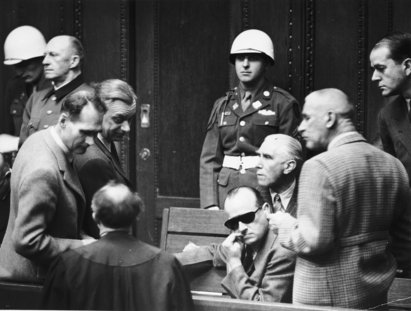 Die Angeklagten Rudolf Hess, Alfred Rosenberg, Hans Frank, Franz von Papen, Wilhelm Frick, Albert Speer und Alfred Jodl unterhalten sich in einer Pause während der Nürnberger Prozesse, 1946, USHMM Die Angeklagten Rudolf Hess, Alfred Rosenberg, Hans Frank, Franz von Papen, Wilhelm Frick, Albert Speer und Alfred Jodl unterhalten sich in einer Pause während der Nürnberger Prozesse, 1946, USHMM