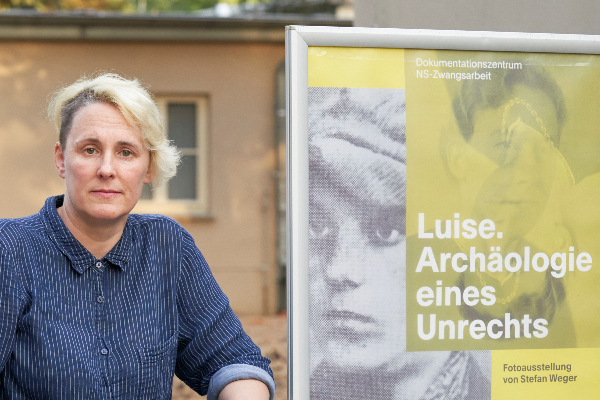 Comic-Zeichnerin Elke R. Steiner Die Comic-Zeichnerin Elke R. Steiner neben dem Plakat zur Ausstellung